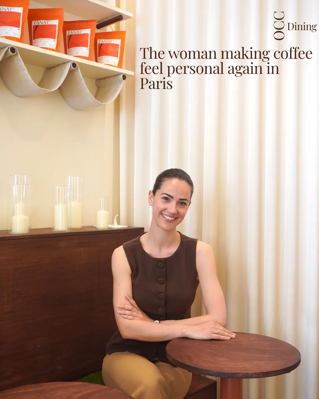 Mathilde, founder of Dialogues Coffee, seated at a dark wood table against cream curtains.